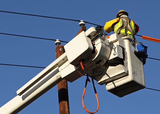 Forest Electric technician working on power lines