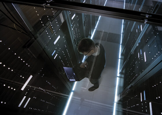 Man working on a laptop in a high-tech data center
